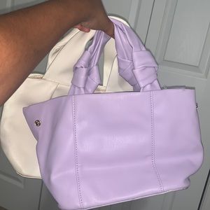 Two mini gently worn handbags. One purple and the second handbag is white.